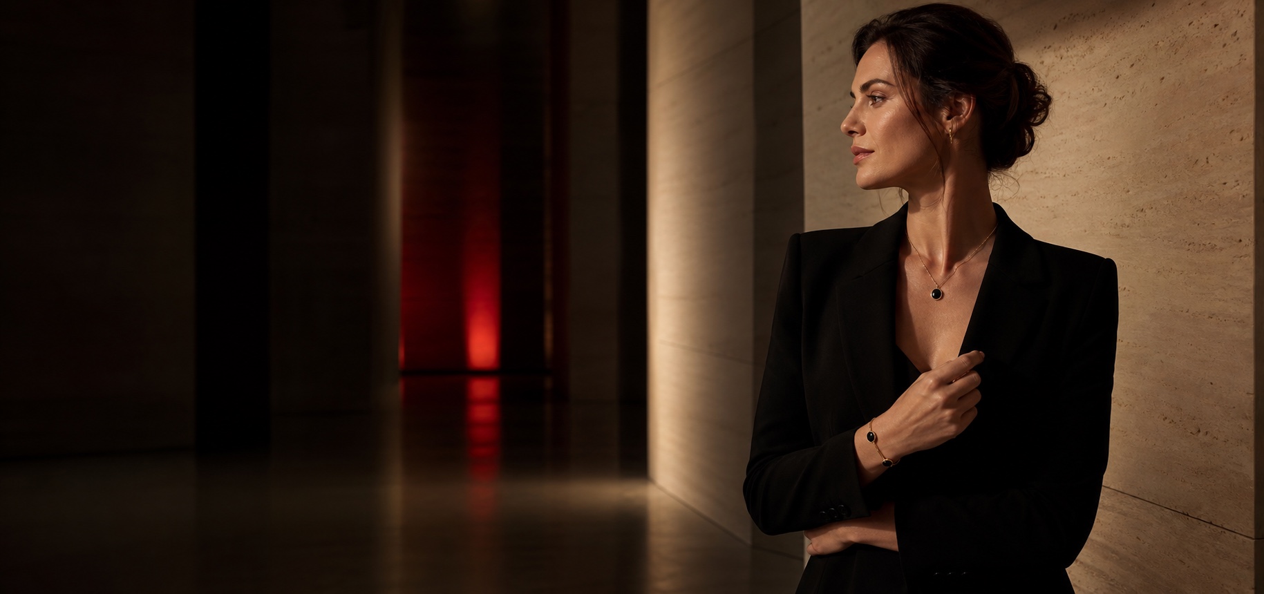 Woman wearing discreet IRIS jewelry in a dark gallery corridor