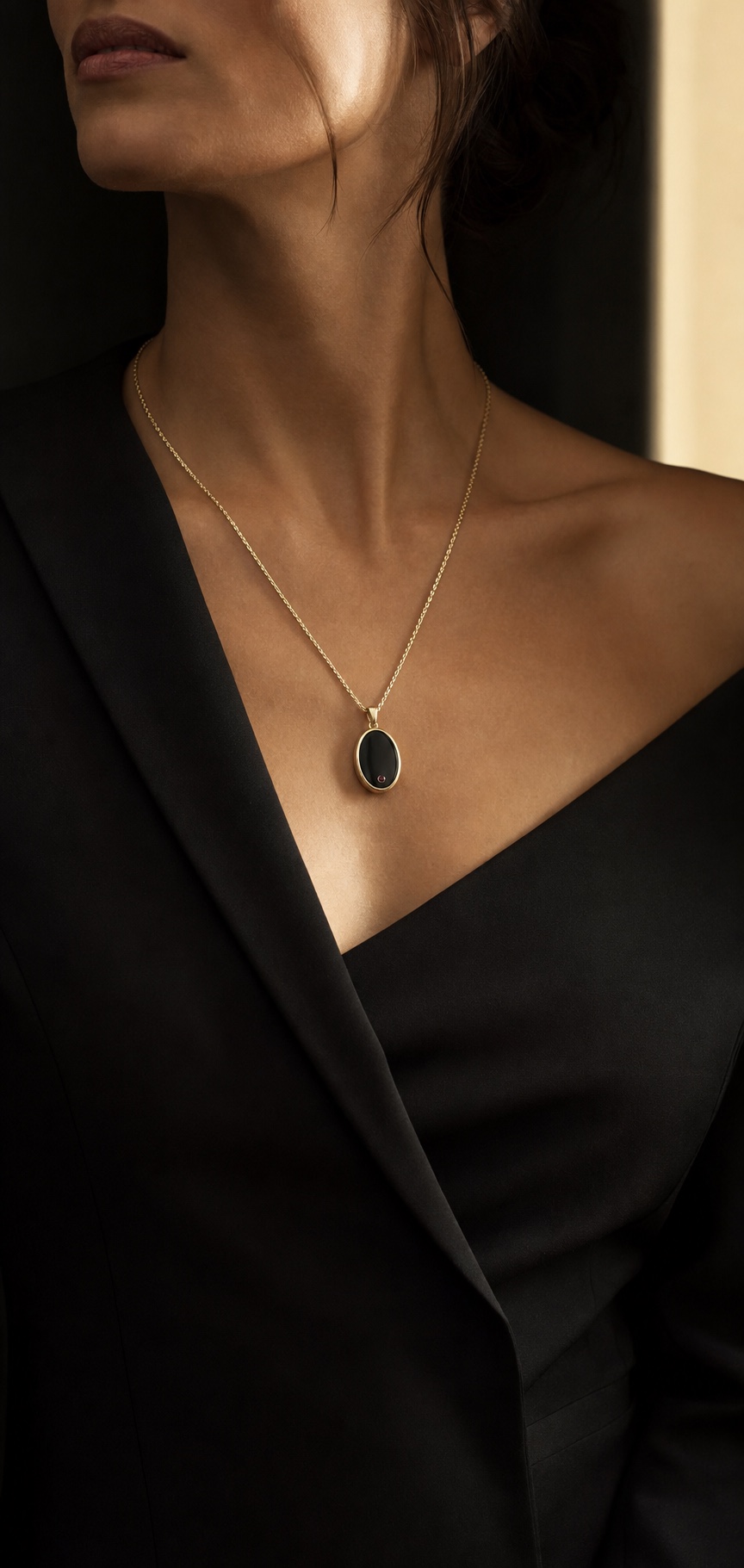 IRIS Lumen miniature obsidian necklace worn with a black tailored jacket